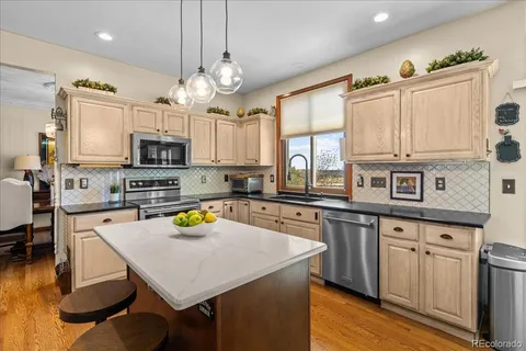 a kitchen with a table chairs microwave and cabinets