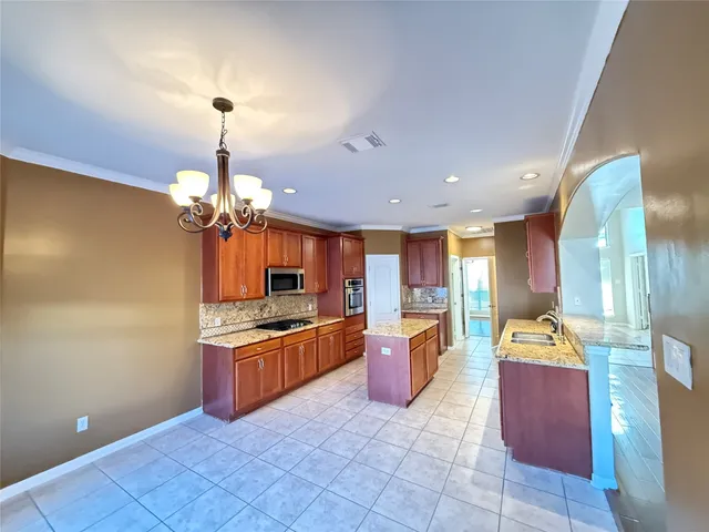 a kitchen with stainless steel appliances granite countertop a sink and a refrigerator