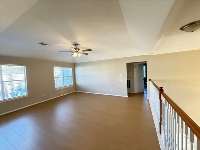 a view of a livingroom with wooden floor and a ceiling fan