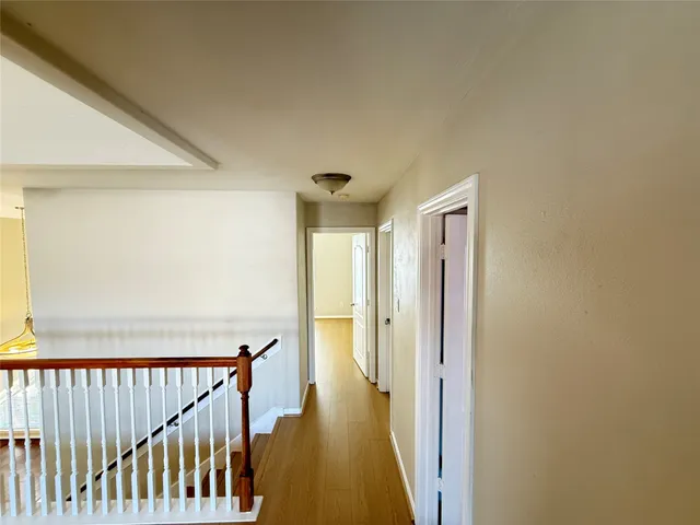 a view of a hallway with wooden floor and staircase