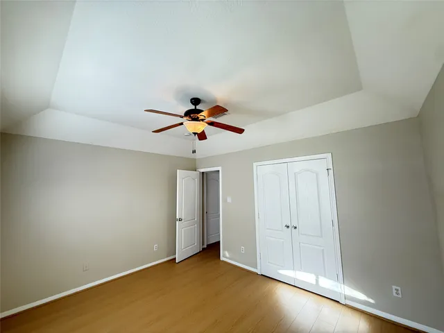an empty room with a window and a ceiling fan