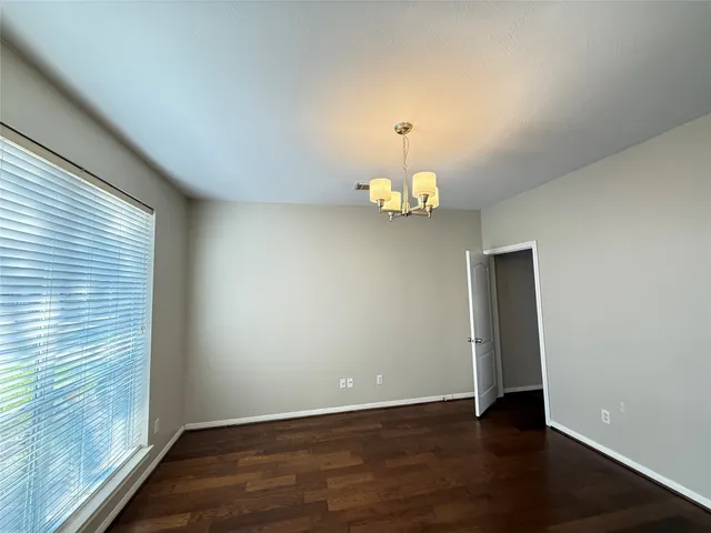 an empty room with wooden floor and window