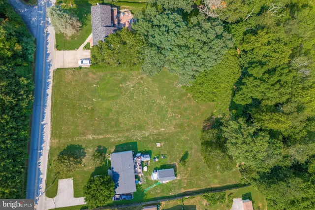 an aerial view of residential houses with outdoor space and trees