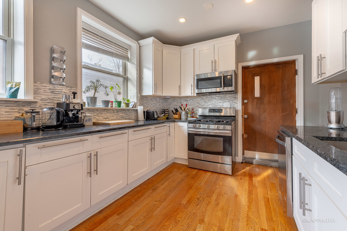 1323 West Addison Street, Unit 1B Chicago, IL 60613 - Photo 14 of 25 a kitchen with stainless steel appliances granite countertop a stove a sink and white cabinets