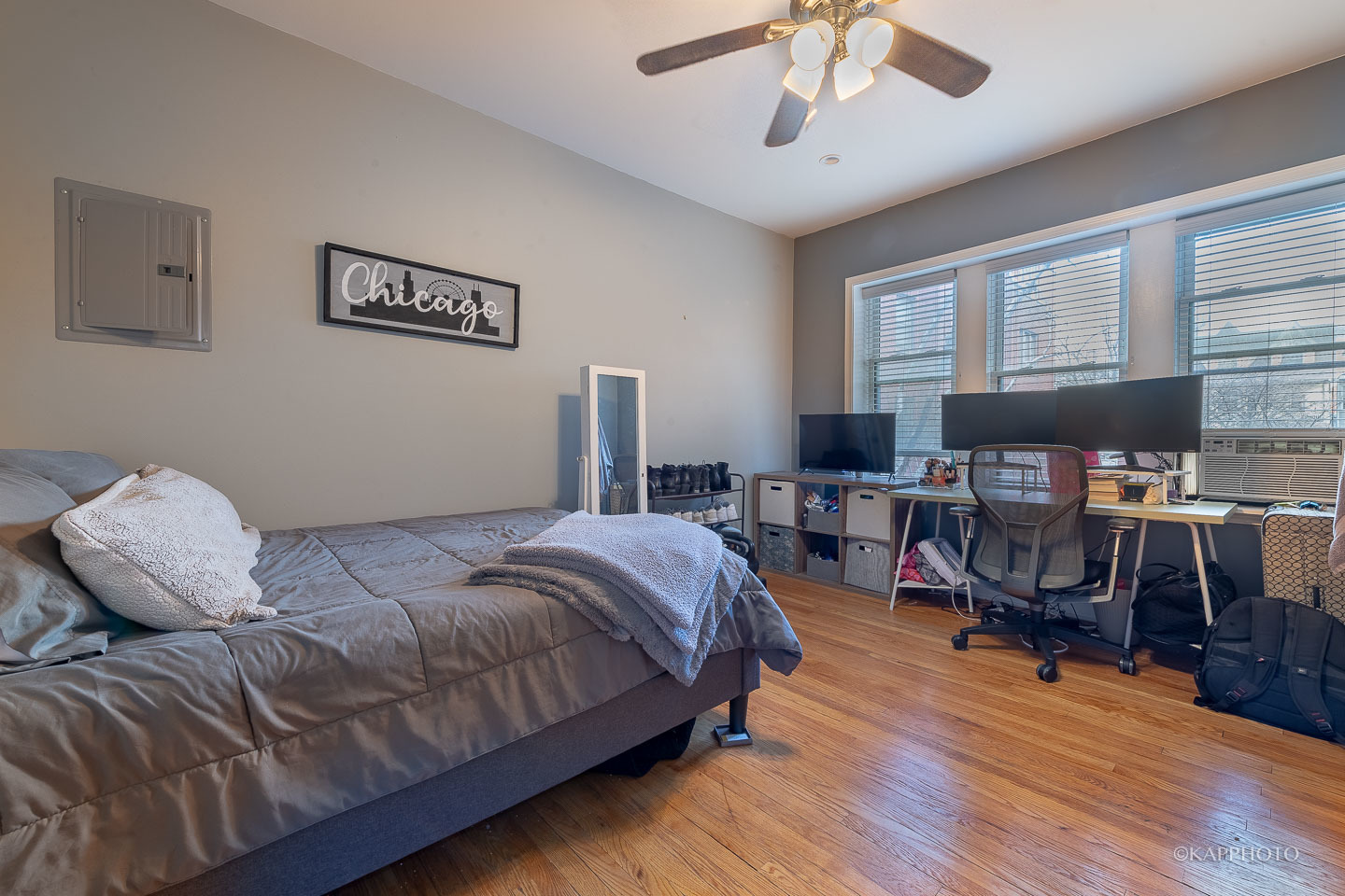 1323 West Addison Street, Unit 1B Chicago, IL 60613 - Photo 21 of 25 a bedroom with a bed a dresser and wooden floor