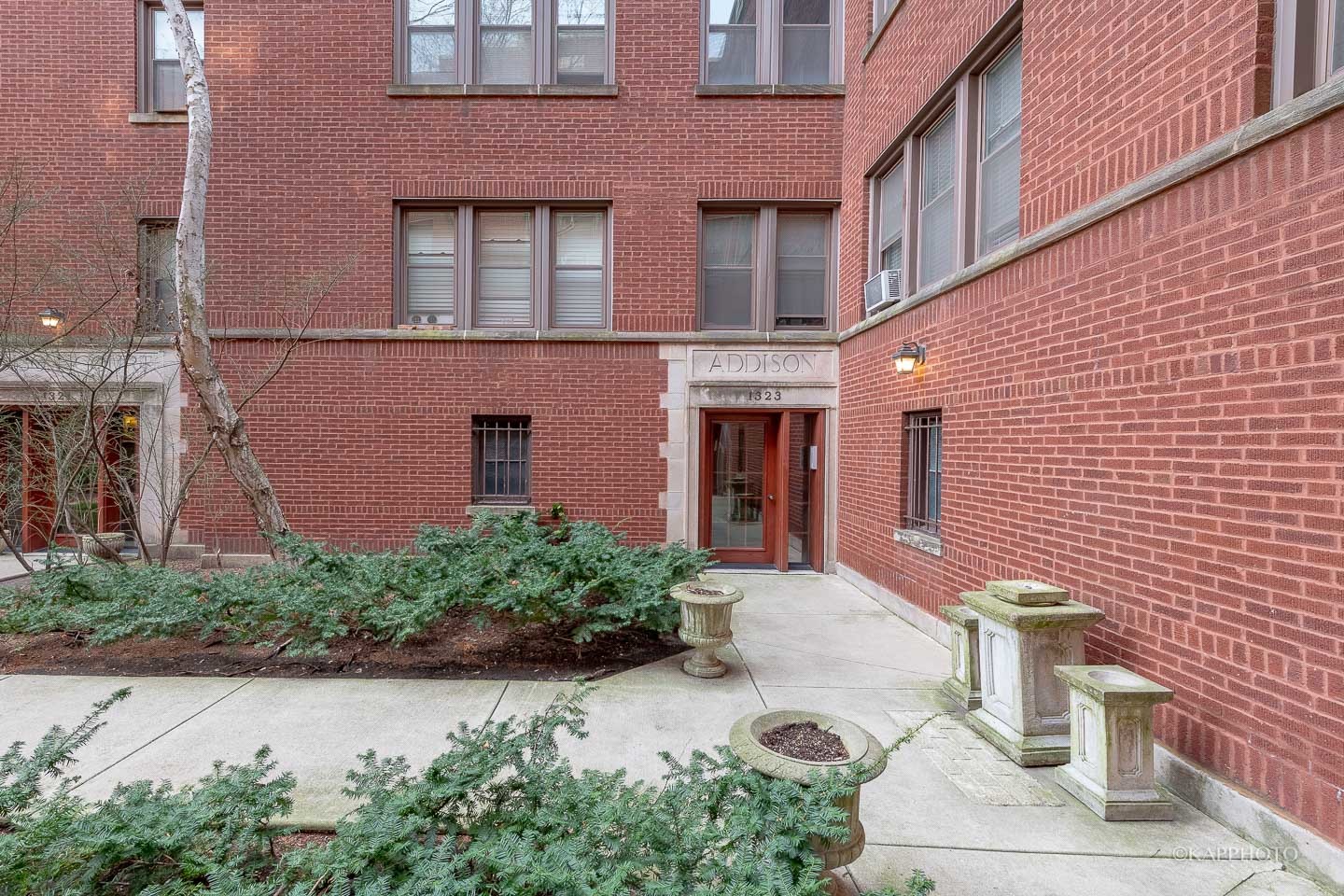 1323 West Addison Street, Unit 1B Chicago, IL 60613 - Photo 3 of 25 a brick building with a yard