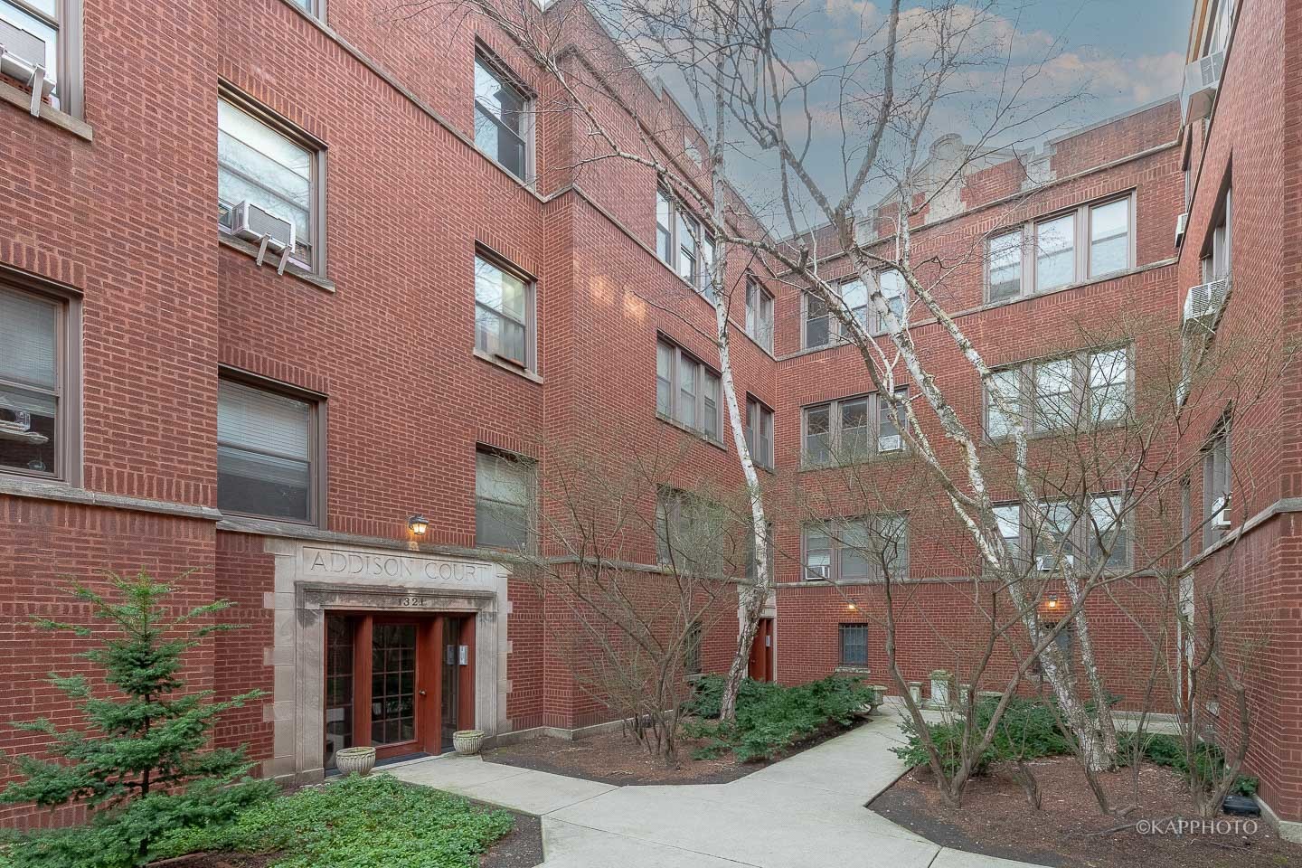 1323 West Addison Street, Unit 1B Chicago, IL 60613 - Photo 4 of 25 a view of a brick building next to a yard