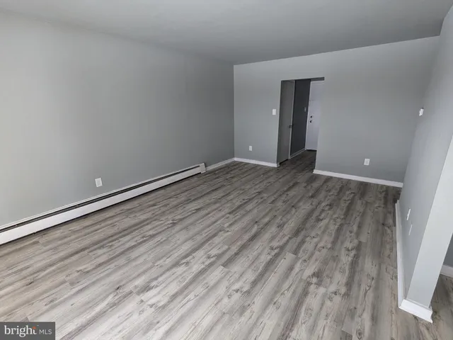 a view of an empty room with wooden floor