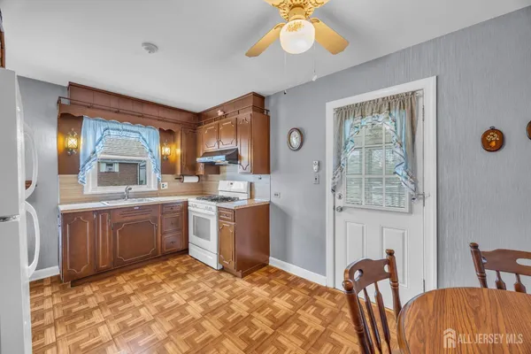 a kitchen with stainless steel appliances granite countertop a sink a stove a dining table and chairs