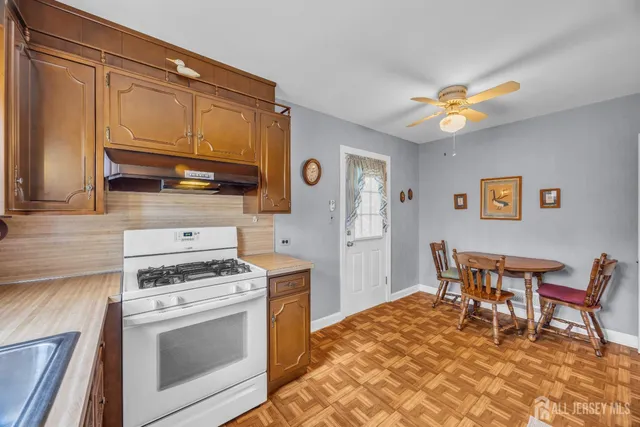 a kitchen with stainless steel appliances granite countertop a stove a sink dishwasher and a refrigerator with wooden cabinets