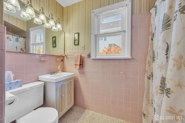 a bathroom with a toilet sink and mirror