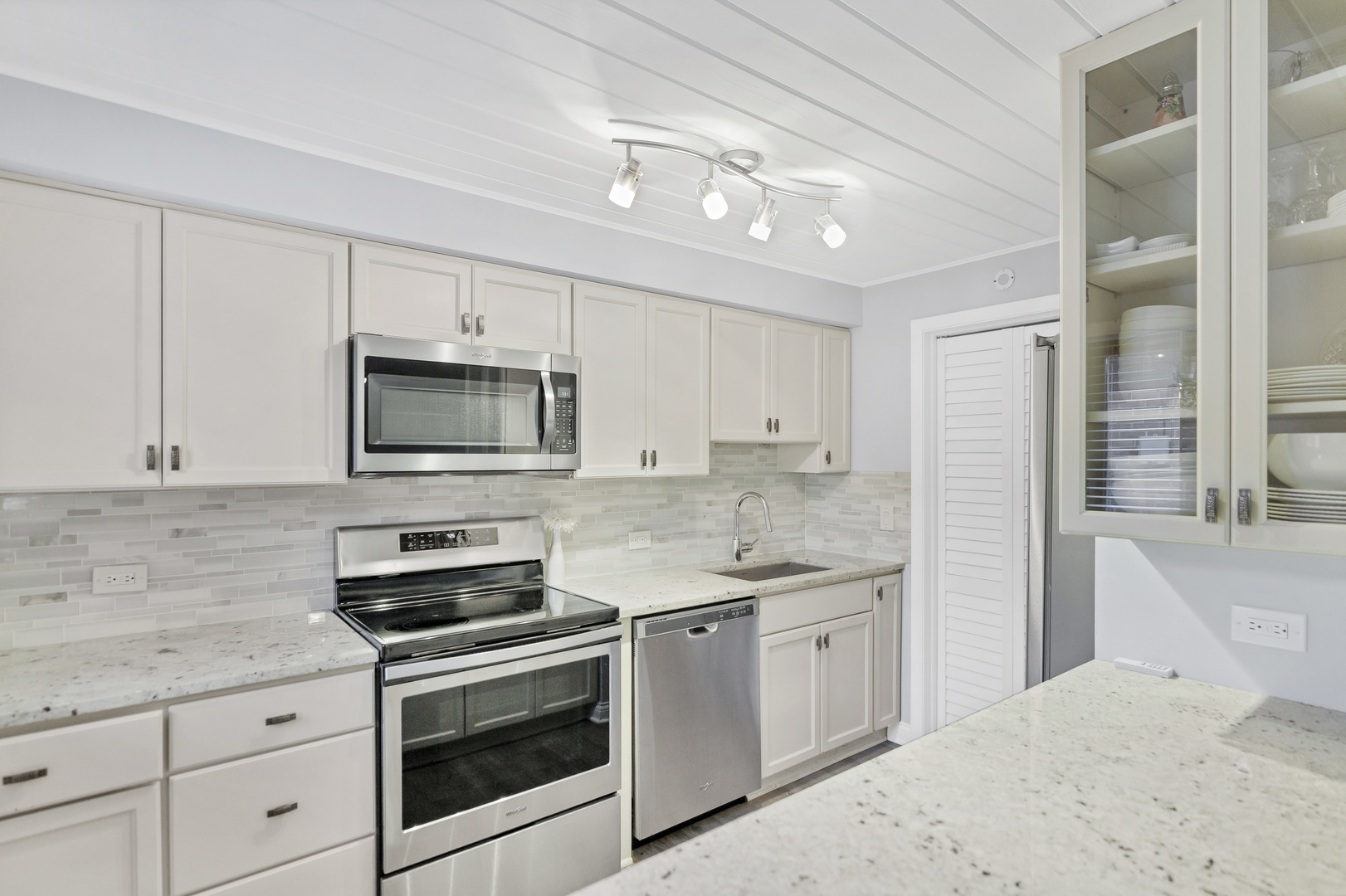 7754 West Higgins Road, Unit J Chicago, IL 60631 - Photo 10 of 23 a kitchen with white cabinets stainless steel appliances and sink