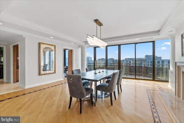 a dining room with wooden floor a chandelier a glass table and chairs