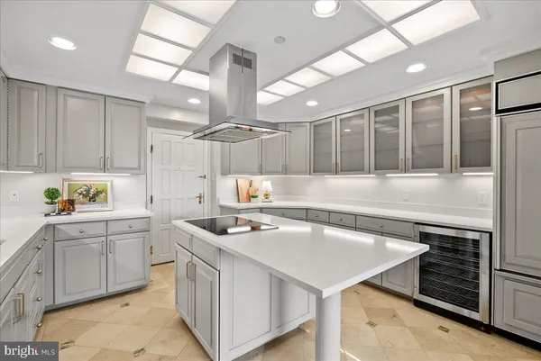 a kitchen that has a sink a stove and chairs in it