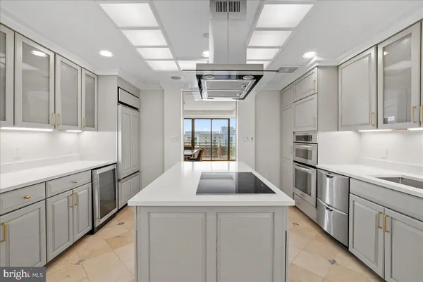 a kitchen with kitchen island granite countertop a sink stainless steel appliances and cabinets