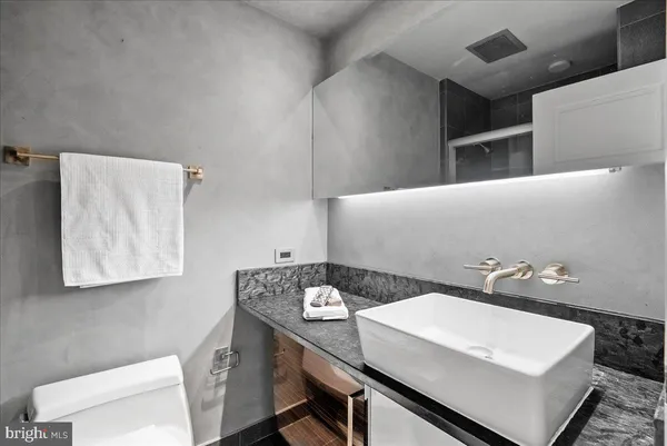 a bathroom with a sink a toilet and a mirror