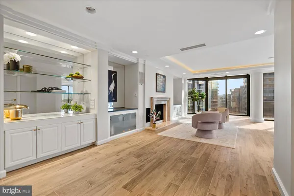 a large white kitchen with cabinets a sink and wooden floor