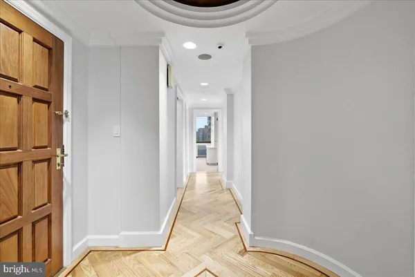 a view of a hallway with wooden floor and staircase