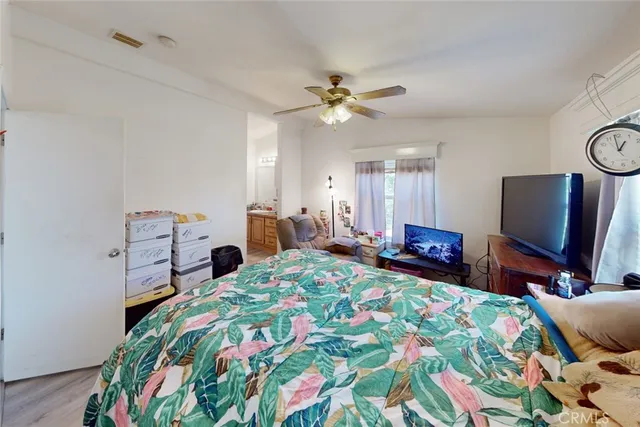 a bedroom with a bed window and a flat screen tv