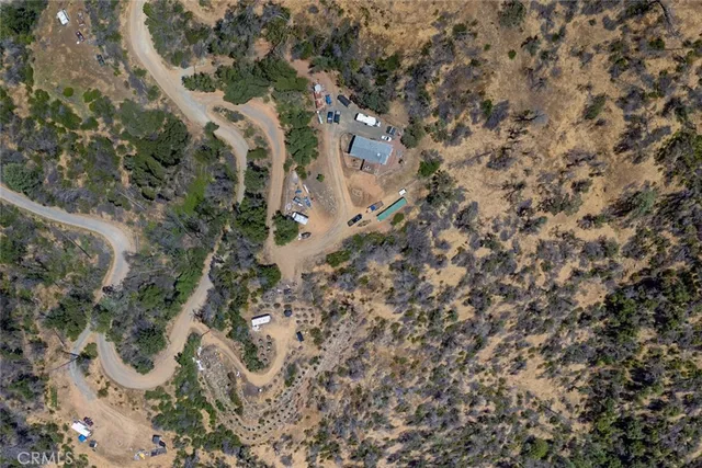 a aerial view of a house with a yard and mountain view in back