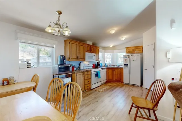a view of a dining room with furniture a chandelier and wooden floor