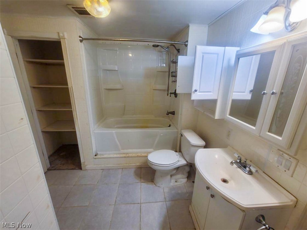 109 Harper Road Streetsboro, OH 44241 - Photo 20 of 28 Full bathroom featuring tiled shower / bath, tile floors, tile walls, vanity, and toilet