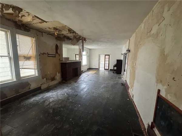 a view of a hallway with a livingroom with furniture wooden floor and windows