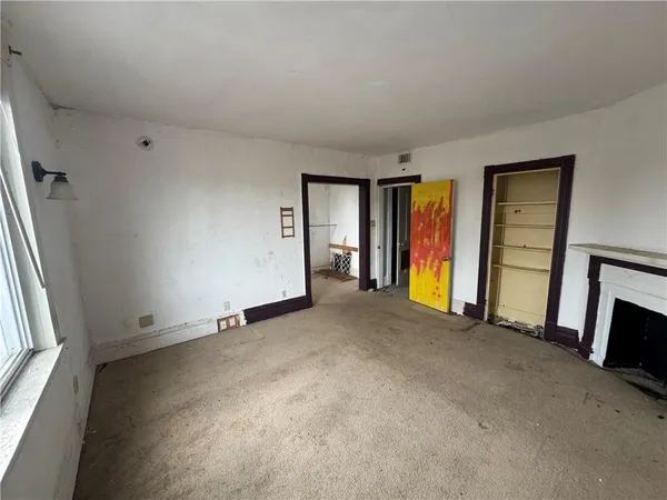 a view of empty room with window and fireplace