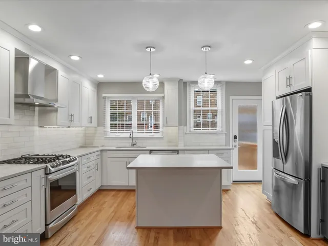 a large kitchen with stainless steel appliances granite countertop a stove and a sink