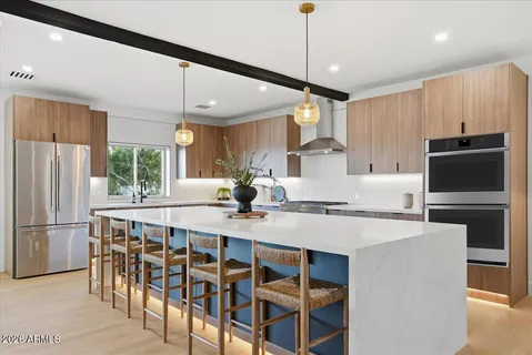 a kitchen with kitchen island a large counter and chairs