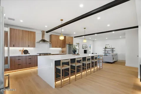 a large white kitchen with lots of counter space wooden floor and stainless steel appliances