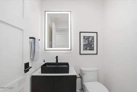 a bathroom with a toilet a sink and mirror