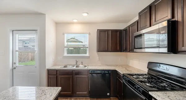 a kitchen with a sink stove and microwave
