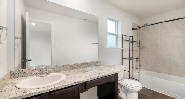 a bathroom with a granite countertop sink toilet and shower
