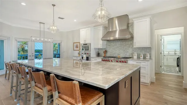 a kitchen with stainless steel appliances granite countertop a kitchen island a stove a table and chairs in it