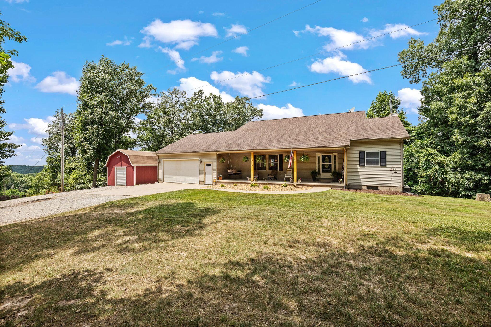 10446 Rich Hollow Road Southwest Lancaster, OH 43130 - Photo 67 of 83 Ranch-style residence featuring a covered front porch with wood columns, an attached garage, and a detached red barn structure