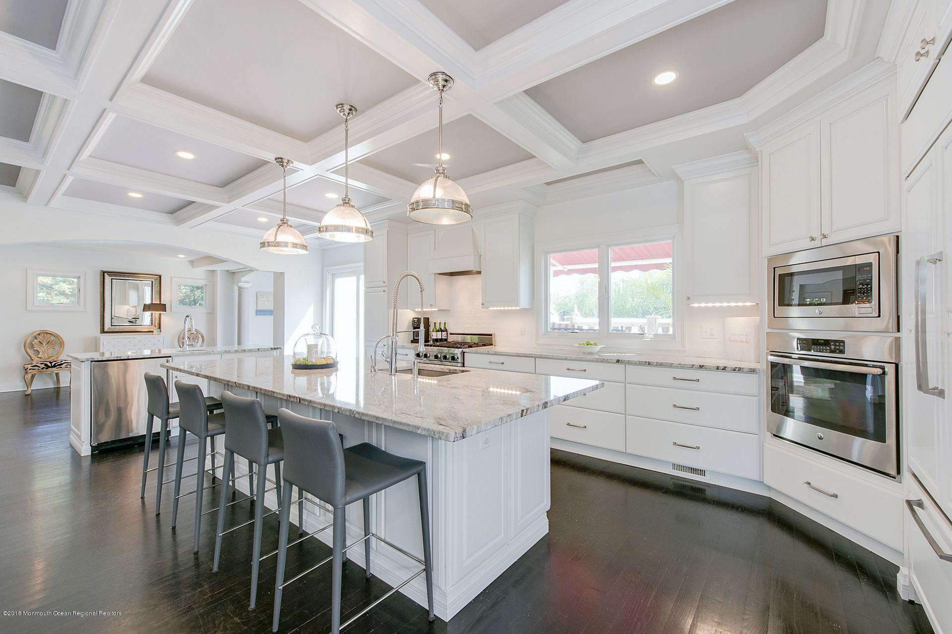 75 Seven Bridges Road Little Silver, NJ 07739 - Photo 1 of 43 a kitchen with stainless steel appliances granite countertop a stove top oven a sink dishwasher a dining table and chairs with wooden floor