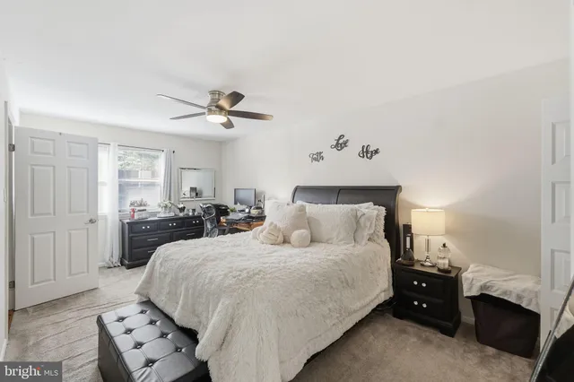 a bedroom with a large bed and a ceiling fan