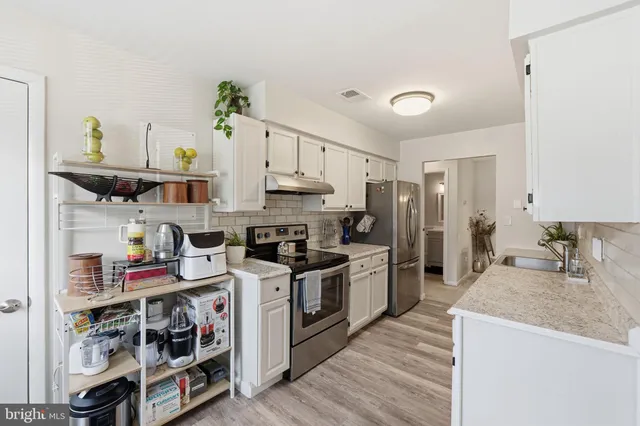 a kitchen with stainless steel appliances granite countertop a stove and a sink