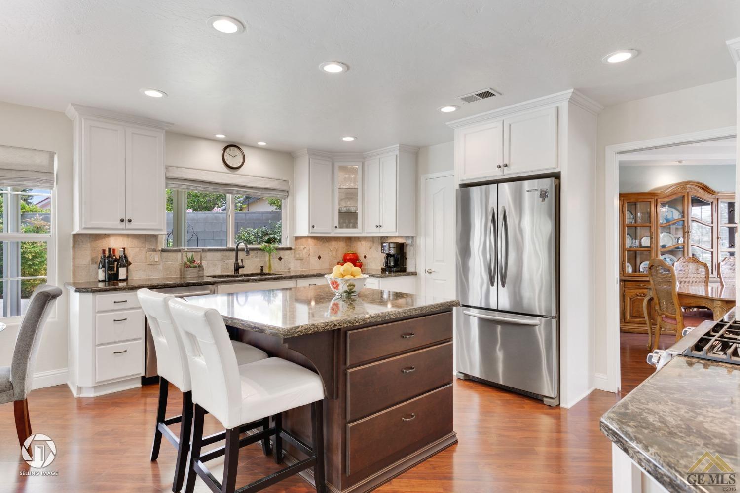 Undisclosed Address Bakersfield, CA 93311 - Photo 20 of 51 a kitchen with kitchen island white cabinets and stainless steel appliances