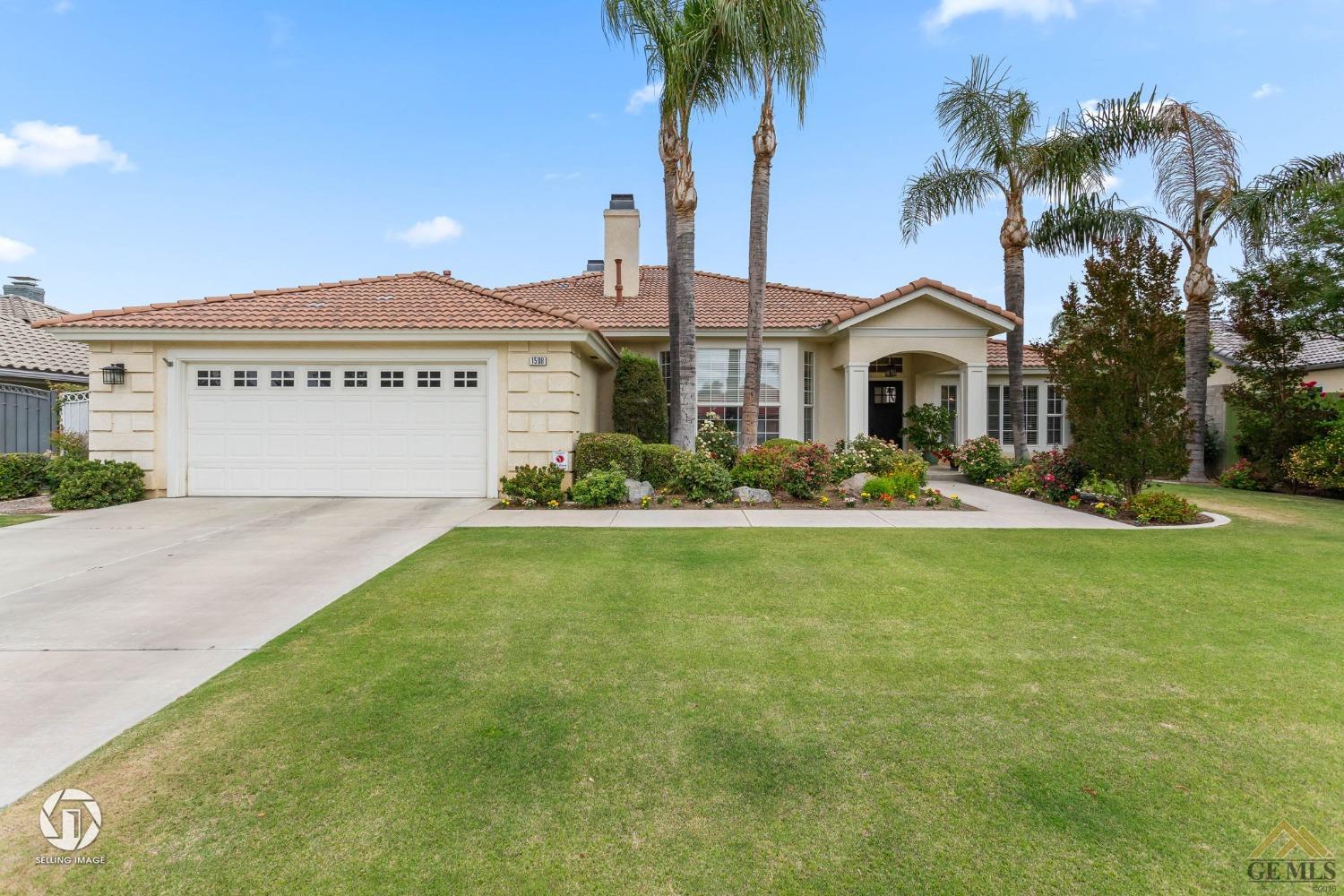 Undisclosed Address Bakersfield, CA 93311 - Photo 4 of 51 a front view of a house with a garden and palm trees