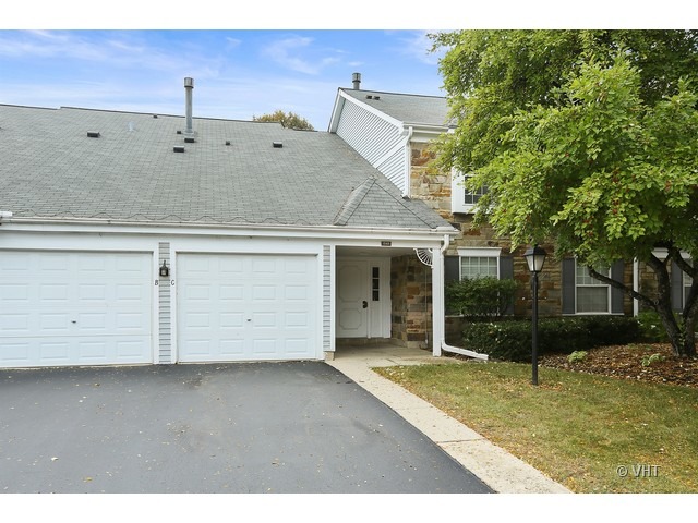 1549 Sandhurst Court, Unit B Wheaton, IL 60189 - Photo 1 of 11 a view of a white house with a yard