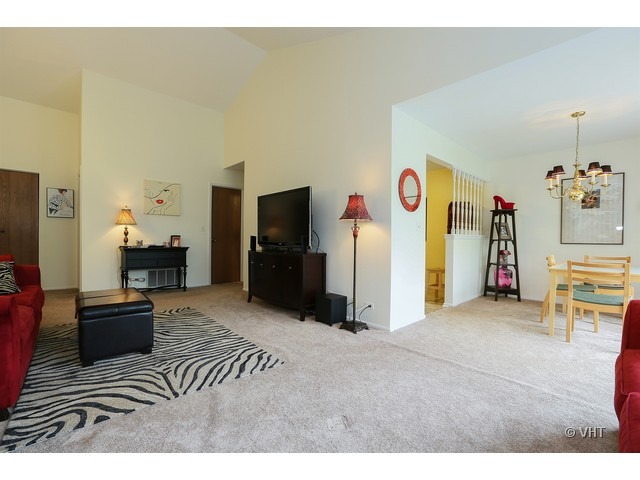 1549 Sandhurst Court, Unit B Wheaton, IL 60189 - Photo 3 of 11 a living room with furniture and a flat screen tv