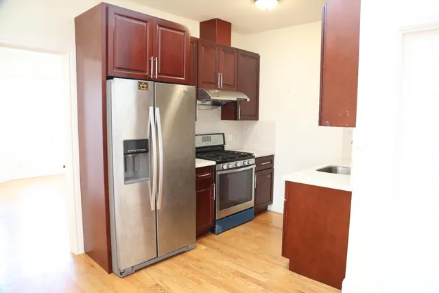 a kitchen with stainless steel appliances granite countertop a refrigerator and a sink