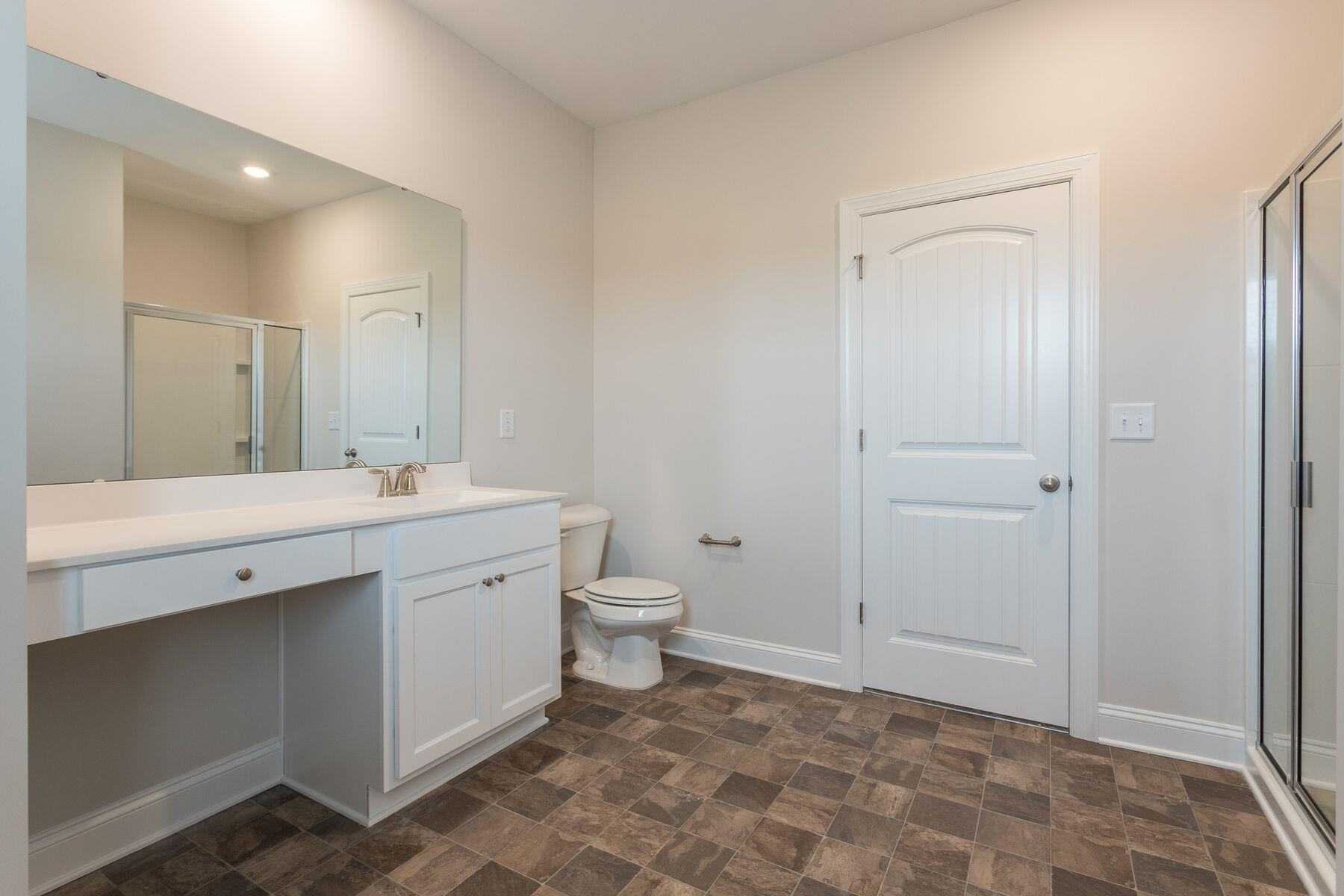 40 Symmetry Loop Youngsville, NC 27596 - Photo 12 of 17 a spacious bathroom with a double vanity sink a toilet and a mirror