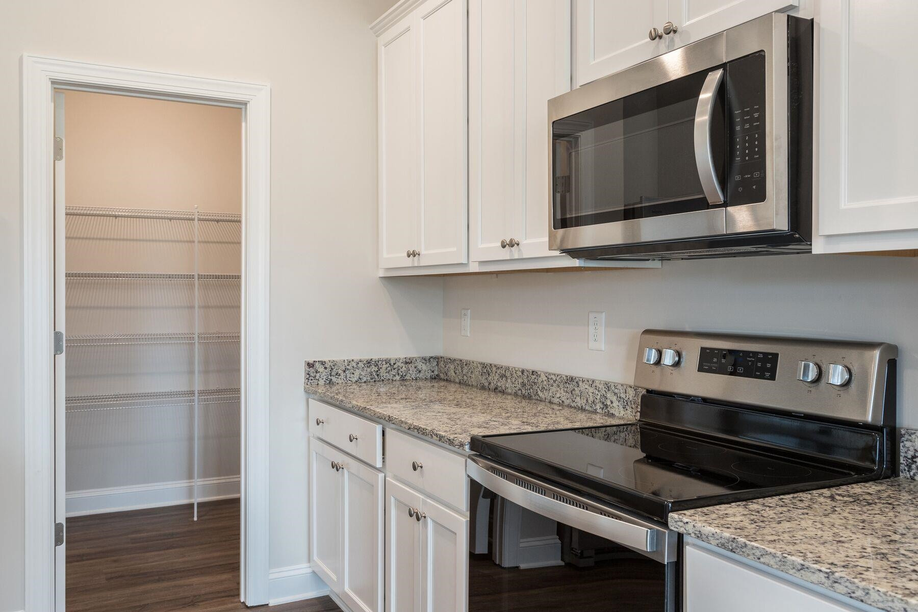40 Symmetry Loop Youngsville, NC 27596 - Photo 7 of 17 a kitchen with granite countertop a stove microwave and sink