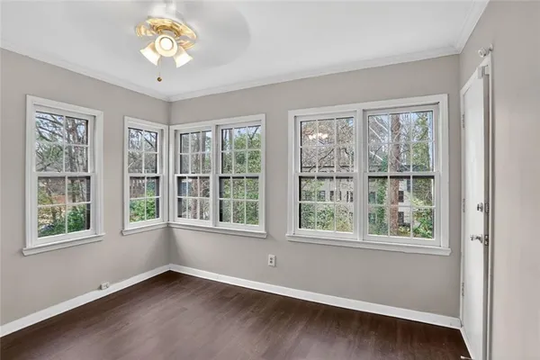 a view of an empty room with a window and wooden floor