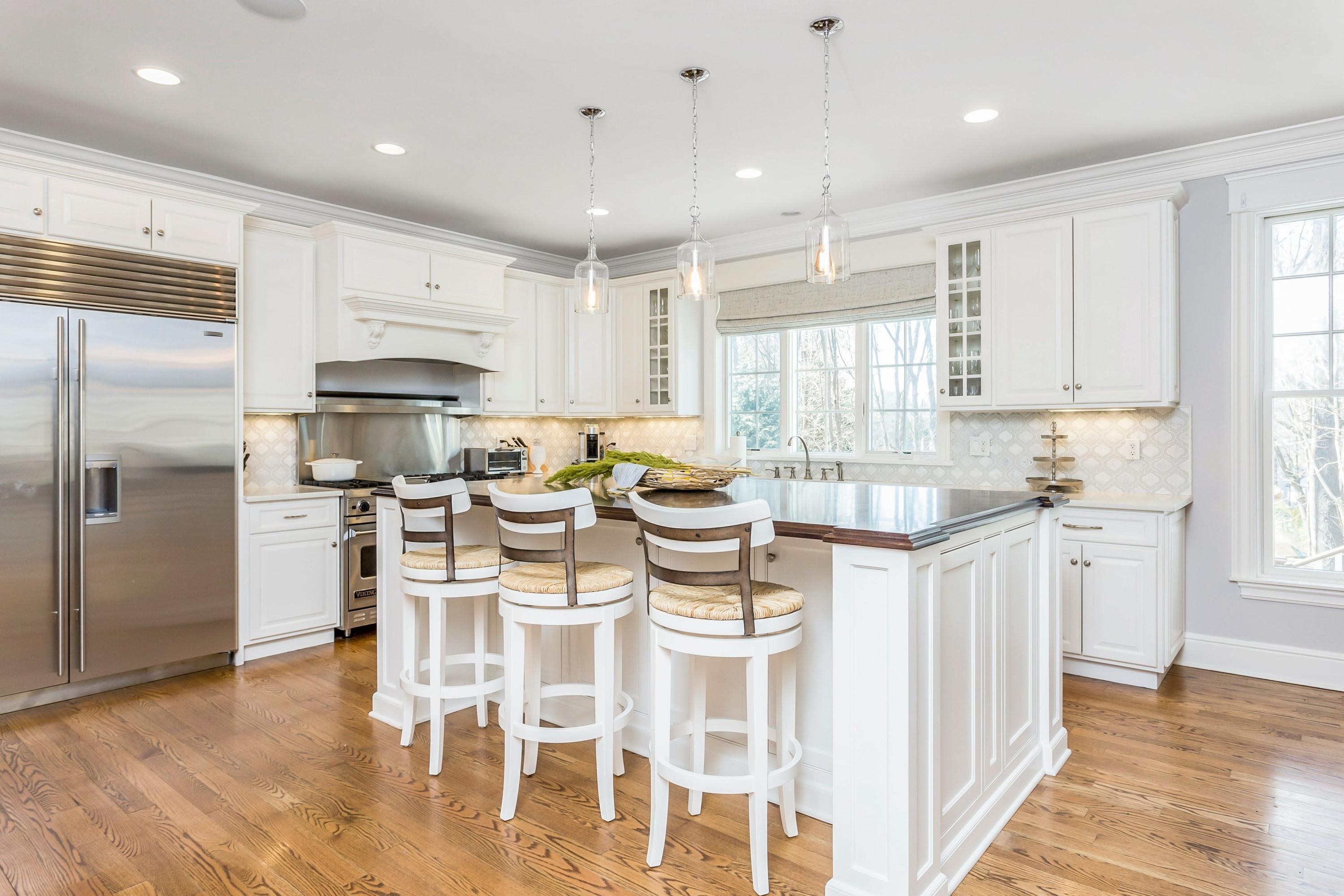 33 Briar Brae Road Darien, CT 06820 - Photo 7 of 37 a kitchen with stainless steel appliances kitchen island granite countertop a table chairs refrigerator and microwave