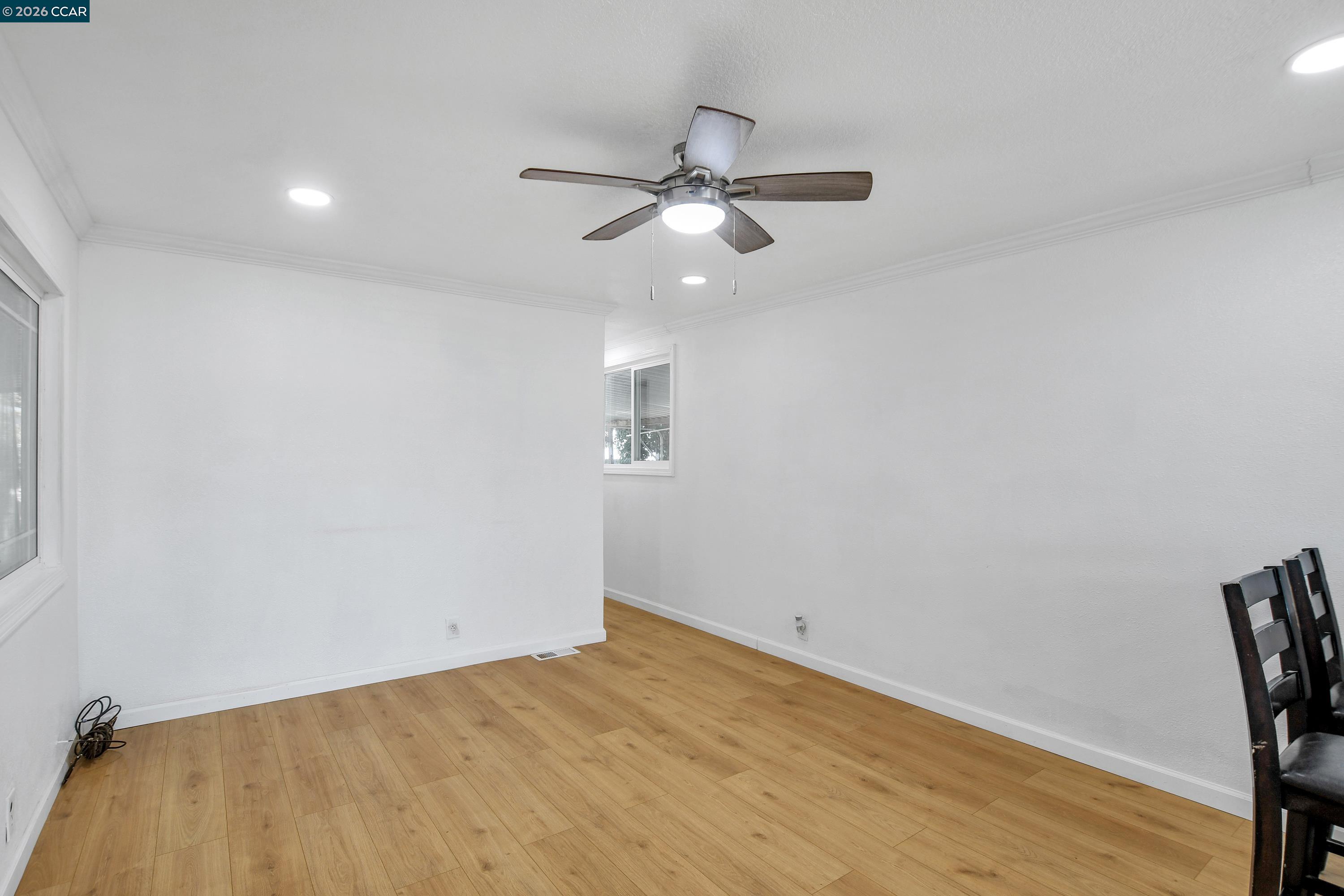 237 Orangevale Pittsburg, CA 94565 - Photo 8 of 21 an empty room with a ceiling fan and wooden floor