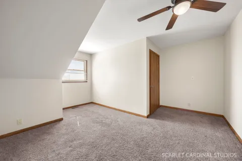 an empty room with windows and ceiling fan